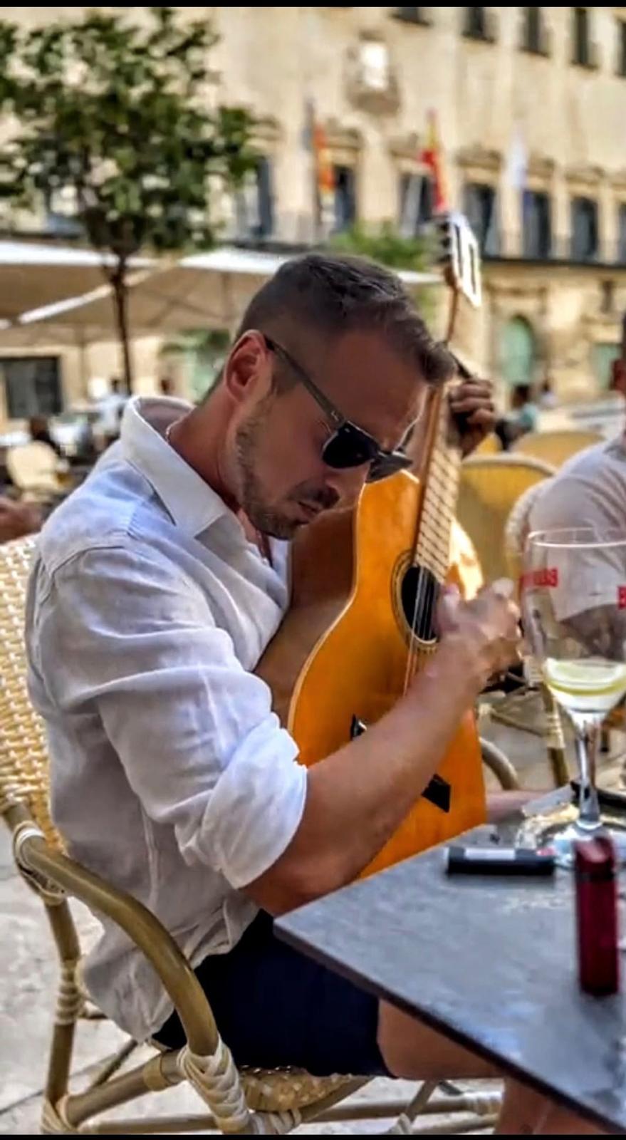 José Blaya tocando la guitarra en una terraza